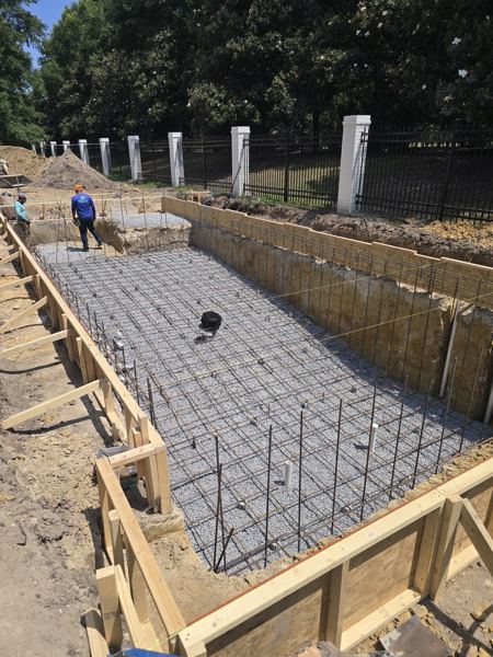 Formed and rebar-reinforced footing trench with stakes and wood forms