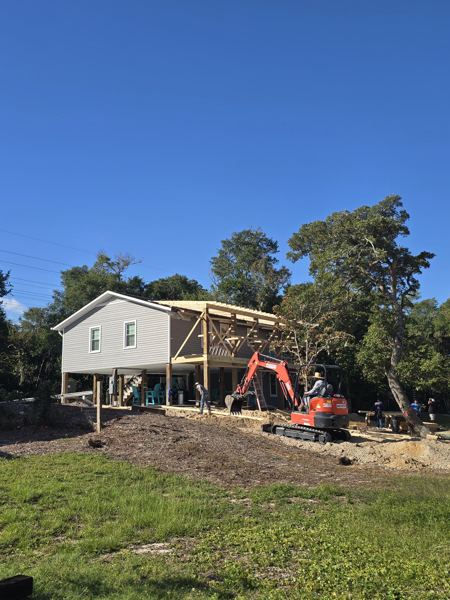 Mini excavator preparing ground at a raised home site