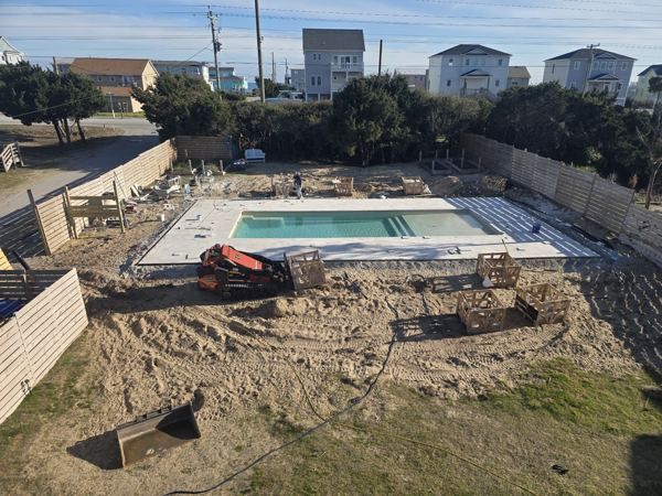 Pool area with new surround work under way behind beach houses
