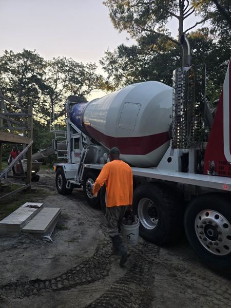 Crew member guiding a ready-mix truck during a pour