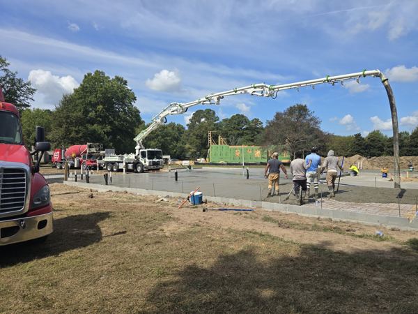 Wide view of a crew and pump truck on a commercial slab pour